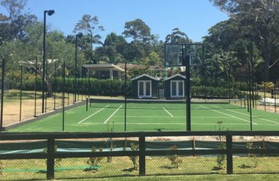 A backyard tennis court looking front on